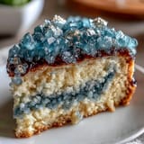 Elegant teal and gold graduation cake featuring a realistic geode slice, combining smooth buttercream with sparkling sugar crystals for a showstopping dessert.