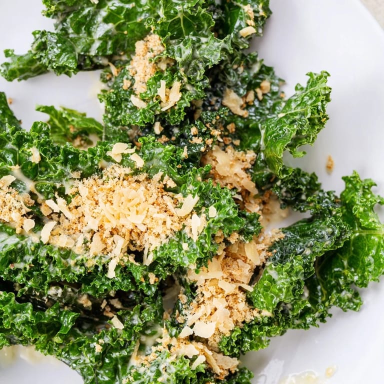 A vibrant bowl of Garlic Parmesan Kale Salad with tender greens, garlic-Parmesan dressing, and crispy panko topping.