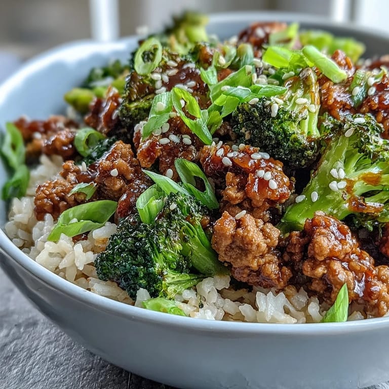 Fork-tender turkey coated in a fiery honey-sriracha sauce atop nutty brown rice, with bright green broccoli and sesame seeds for a dairy-free meal.