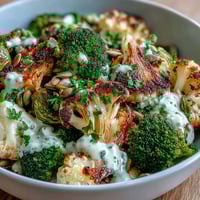 Golden-brown roasted broccoli, cauliflower, and Brussels sprouts fill this hearty Roasted Brassica Bowl, served over fluffy quinoa.